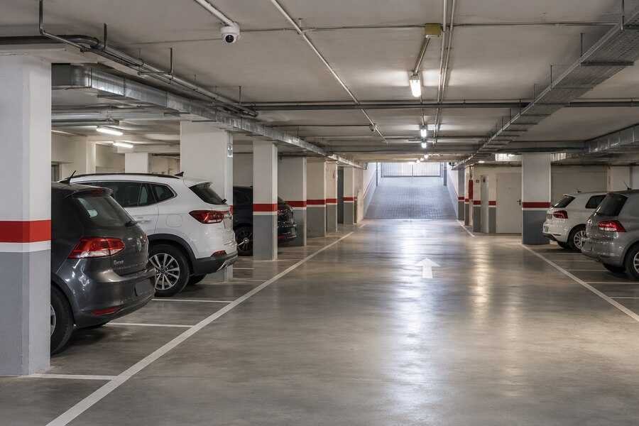 Garaje comunitario con una cámara de videovigilancia orientada hacia la zona de circulación